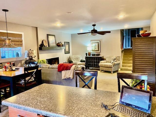 carpeted living room featuring ceiling fan