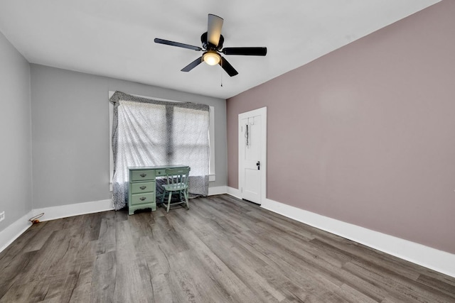  - home office with baseboards, a ceiling fan, and wood finished floors