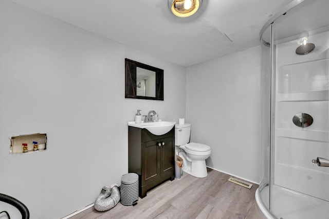  - bathroom featuring toilet, a stall shower, visible vents, wood finished floors, and vanity