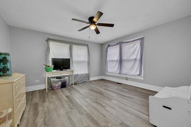 - unfurnished living room featuring wood finished floors, visible vents, baseboards, and ceiling fan