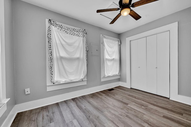  - unfurnished bedroom with ceiling fan, baseboards, wood finished floors, and a closet