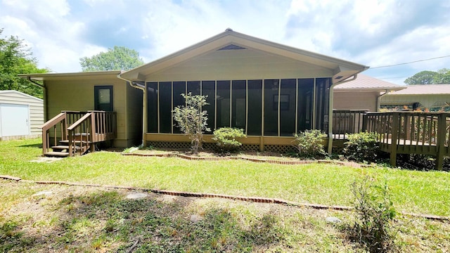 back of property featuring a yard, a deck, and a shed