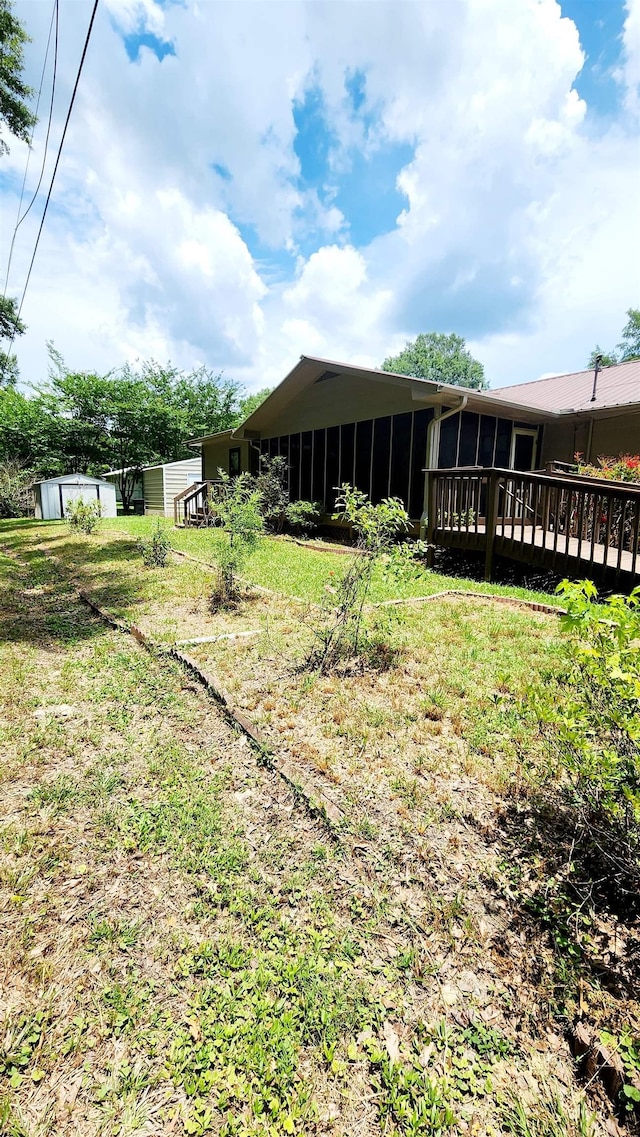 view of yard with a sunroom and a deck