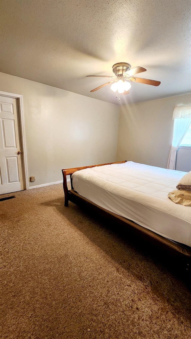 unfurnished bedroom with ceiling fan, carpet floors, and a textured ceiling