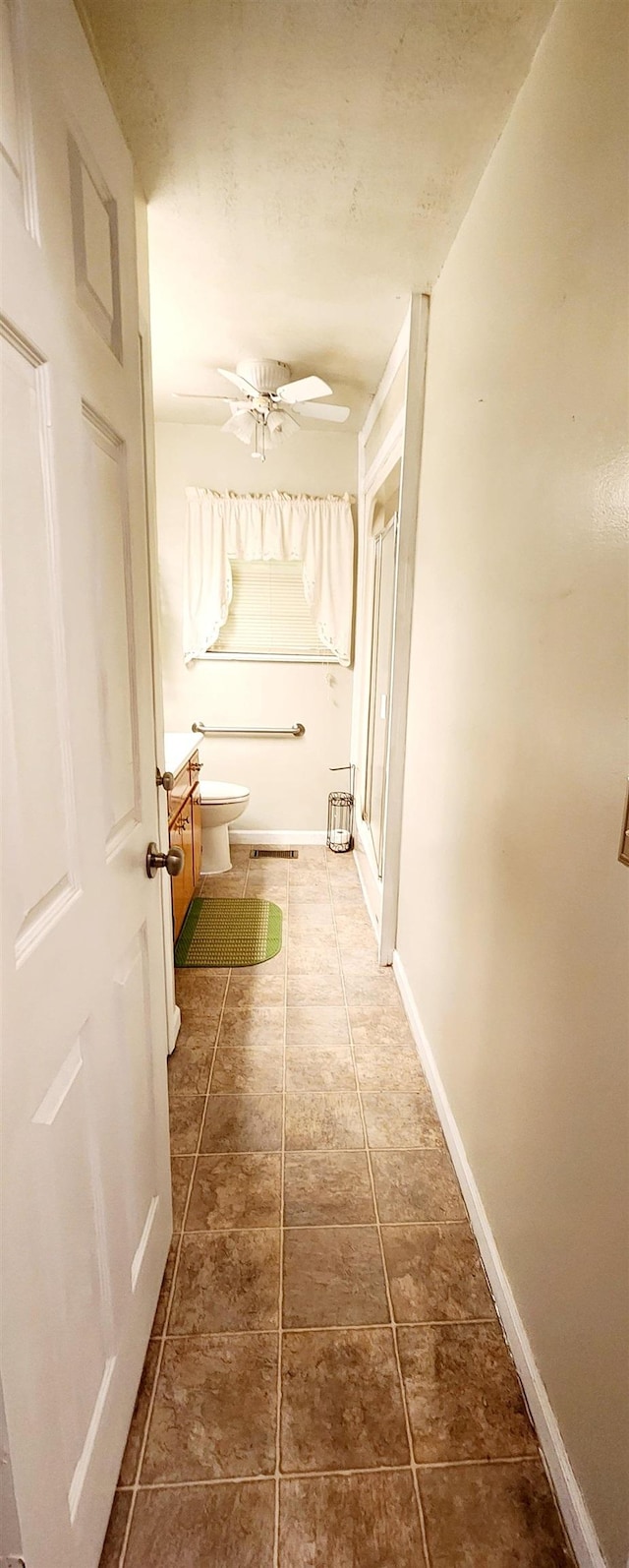 bathroom featuring vanity, toilet, and ceiling fan