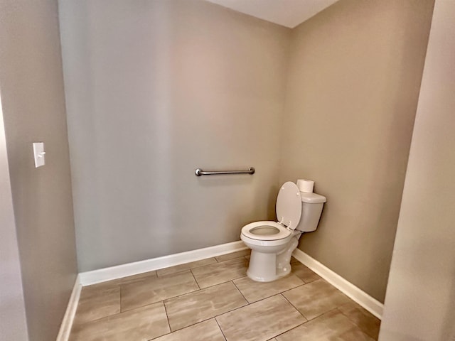  - bathroom with toilet, tile patterned flooring, and baseboards