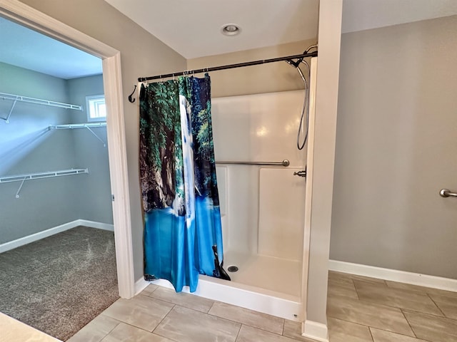  - bathroom with a shower stall, tile patterned flooring, and a walk in closet