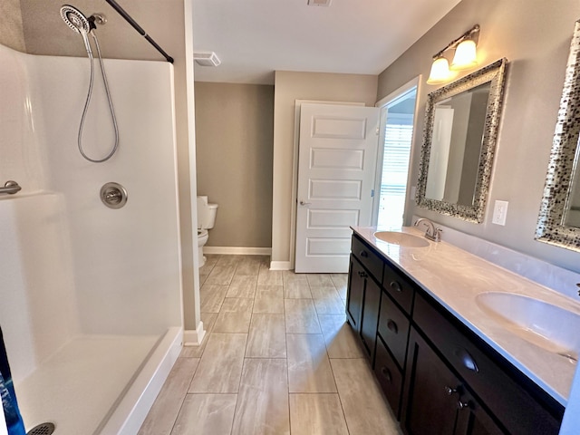  - full bath with double vanity, baseboards, toilet, and a shower