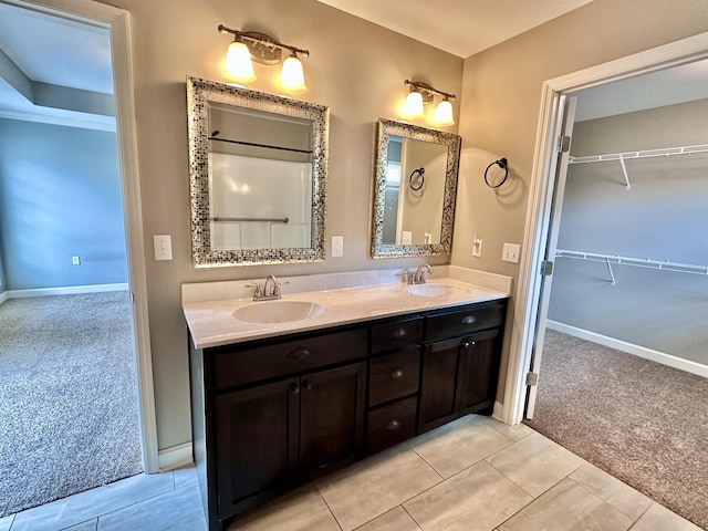  - full bathroom featuring double vanity, tile patterned floors, baseboards, and a spacious closet