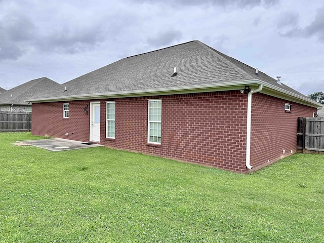  - rear view of house featuring brick siding, a shingled roof, and a patio
