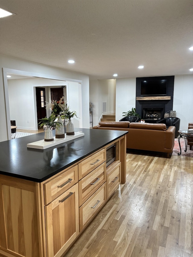 kitchen featuring recessed lighting, visible vents, light wood finished floors, stainless steel microwave, and dark countertops