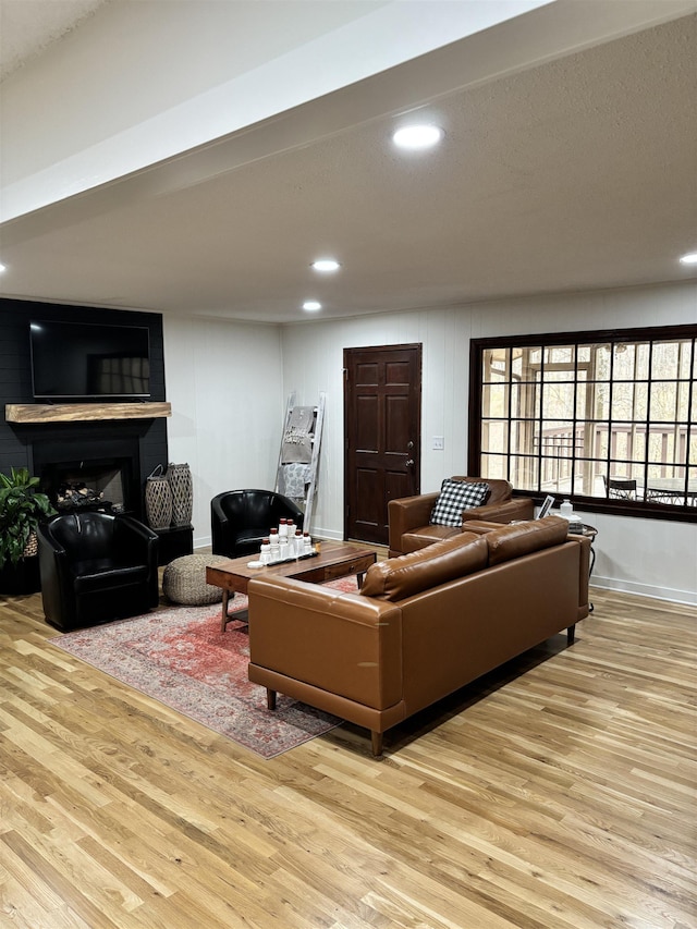 living area featuring baseboards, wood finished floors, and recessed lighting