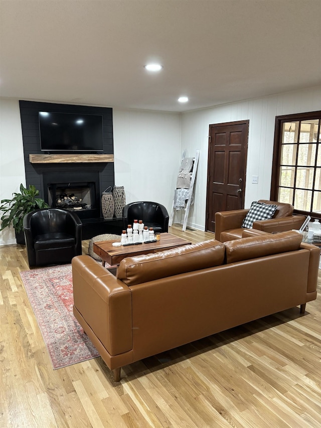 living room featuring recessed lighting, a fireplace, and light wood finished floors