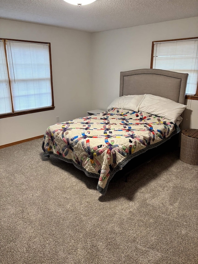 carpeted bedroom with a textured ceiling and baseboards