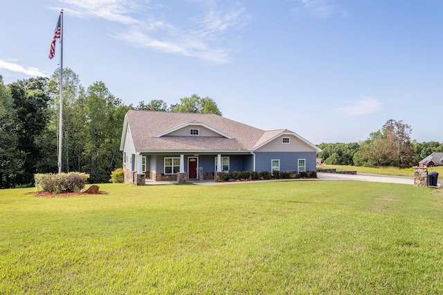 view of front of property featuring covered porch, a shingled roof, and a front yard