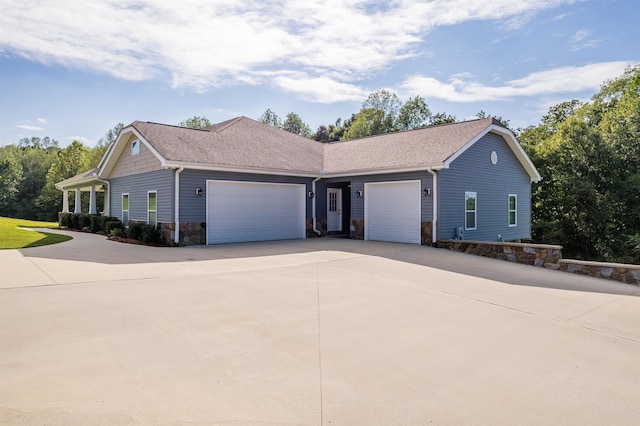 view of home's exterior featuring stone siding, concrete driveway, a garage, and a shingled roof