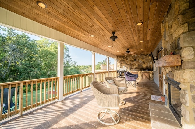 wooden terrace featuring a ceiling fan and grilling area