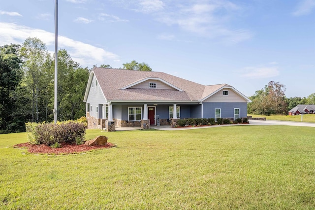 view of front of home featuring stone siding, roof with shingles, a porch, and a front lawn