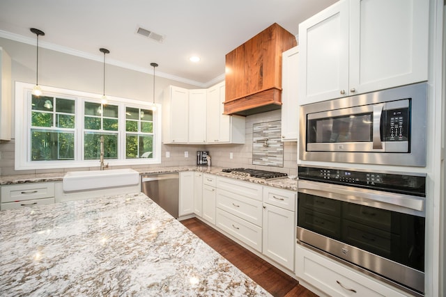 kitchen featuring visible vents, a sink, decorative backsplash, stainless steel appliances, and white cabinets