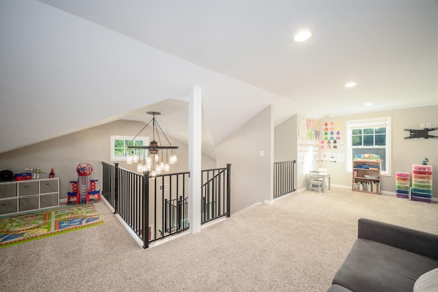 game room with a notable chandelier, carpet flooring, lofted ceiling, and a healthy amount of sunlight