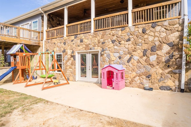 exterior space featuring a balcony, french doors, and stone siding