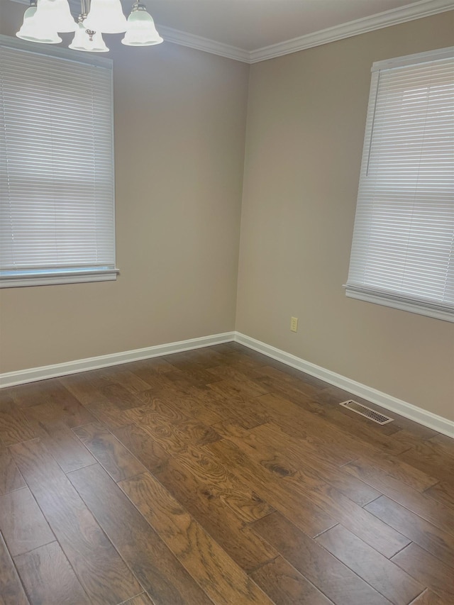 unfurnished room featuring a chandelier, dark hardwood / wood-style flooring, and ornamental molding