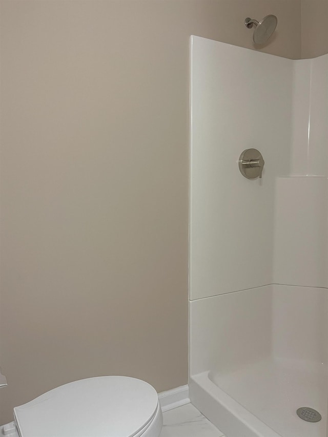 bathroom featuring walk in shower and toilet