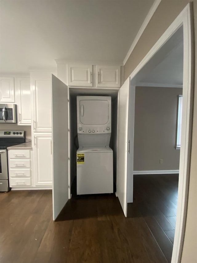 laundry room with dark hardwood / wood-style floors, crown molding, and stacked washer / drying machine