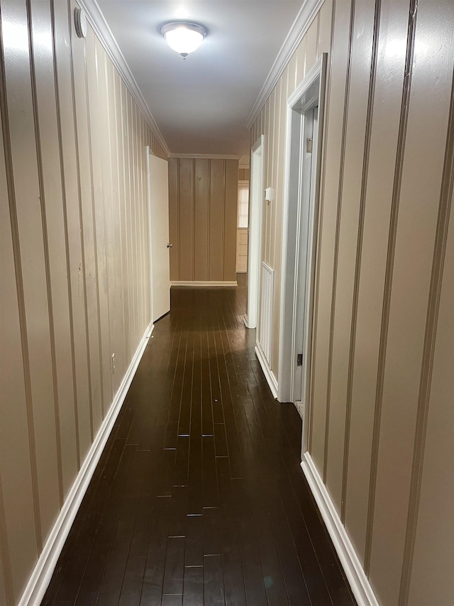 hallway with dark hardwood / wood-style flooring and crown molding