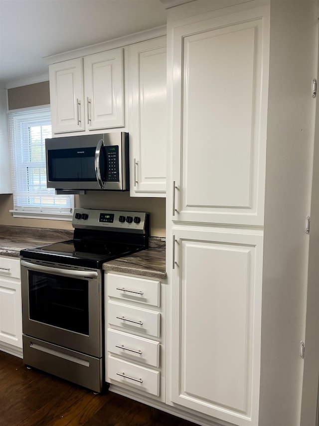 kitchen featuring white cabinets, appliances with stainless steel finishes, and dark hardwood / wood-style floors