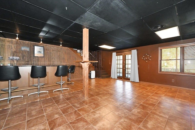  - interior space with tile patterned floors, plenty of natural light, wood walls, and stairs