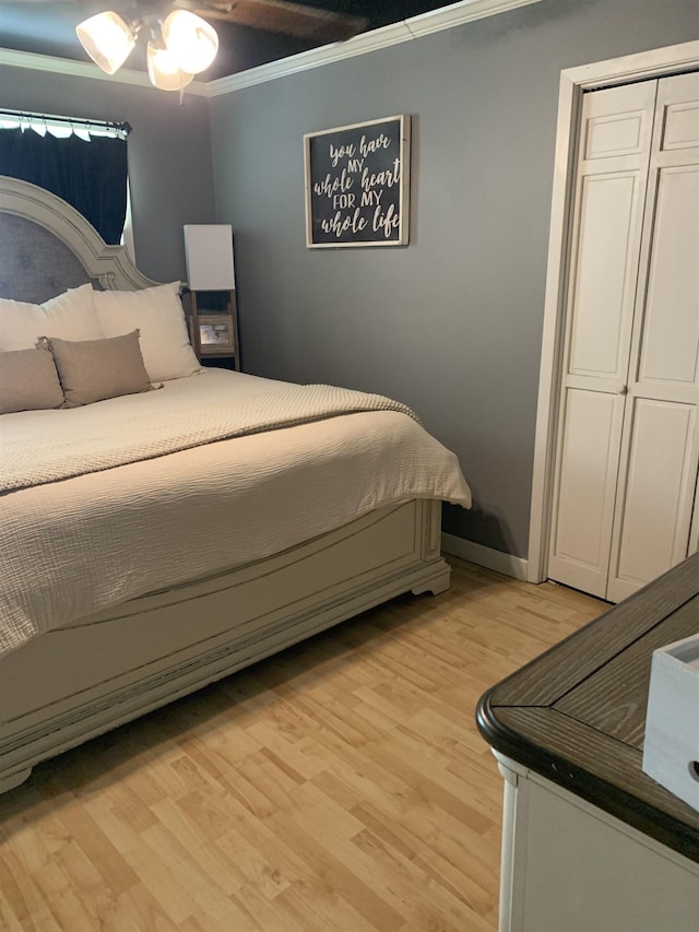 bedroom with light wood-style flooring, a closet, ornamental molding, and baseboards