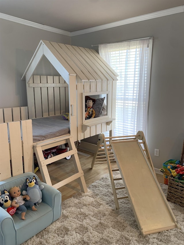 bedroom with light wood-style floors and crown molding