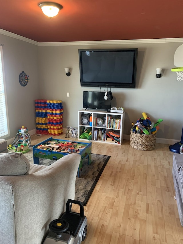 playroom with baseboards, wood finished floors, and crown molding