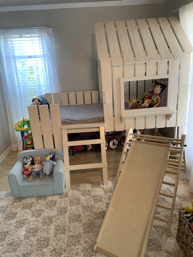 bedroom featuring ornamental molding and light wood-type flooring