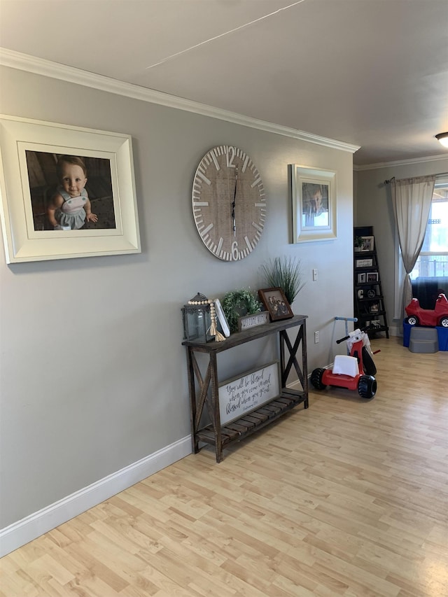 interior space featuring light wood-style floors, baseboards, and ornamental molding