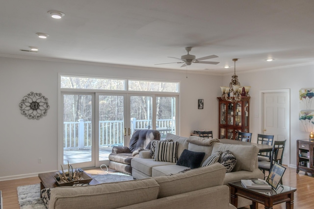 living room featuring hardwood / wood-style floors, crown molding, and ceiling fan with notable chandelier