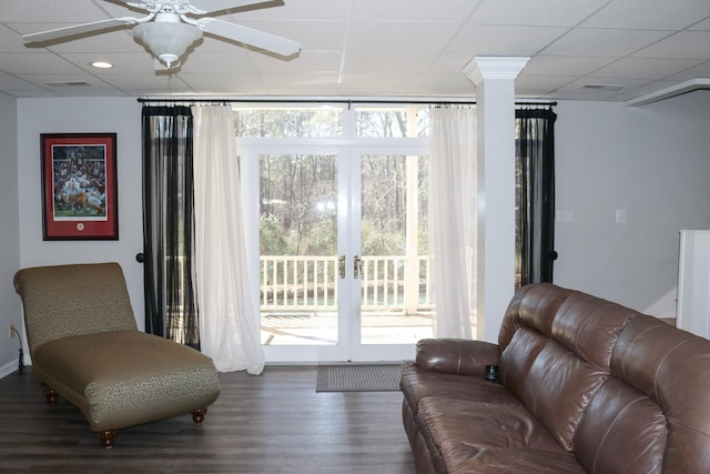 living room featuring hardwood / wood-style flooring, decorative columns, and ceiling fan