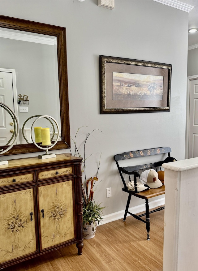 interior space featuring crown molding and light hardwood / wood-style flooring