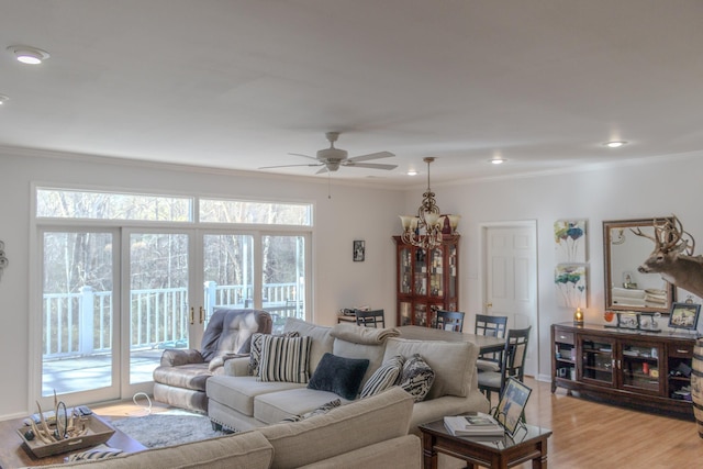 living room featuring crown molding, ceiling fan with notable chandelier, and light wood-type flooring