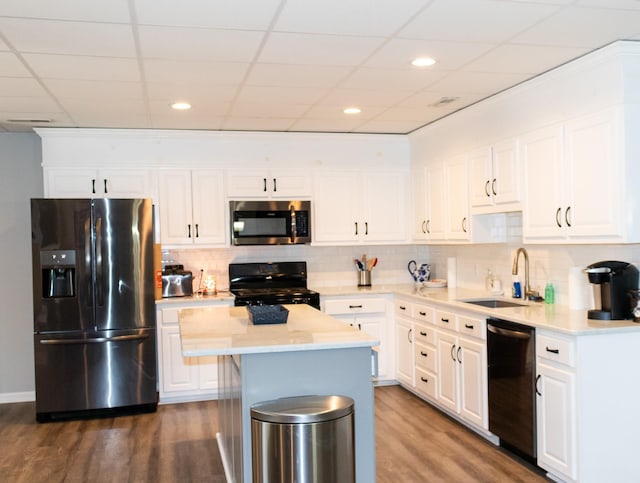 kitchen with white cabinetry, sink, a center island, black appliances, and dark wood-type flooring