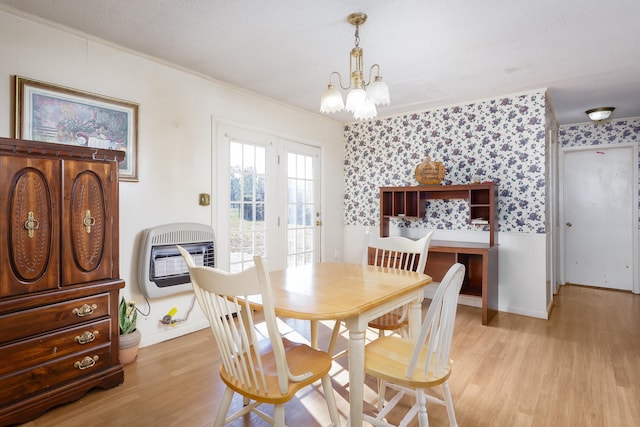 dining space with light hardwood / wood-style floors, an inviting chandelier, crown molding, and heating unit