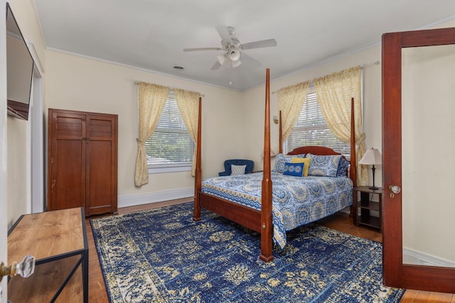 bedroom with crown molding, baseboards, ceiling fan, and wood finished floors