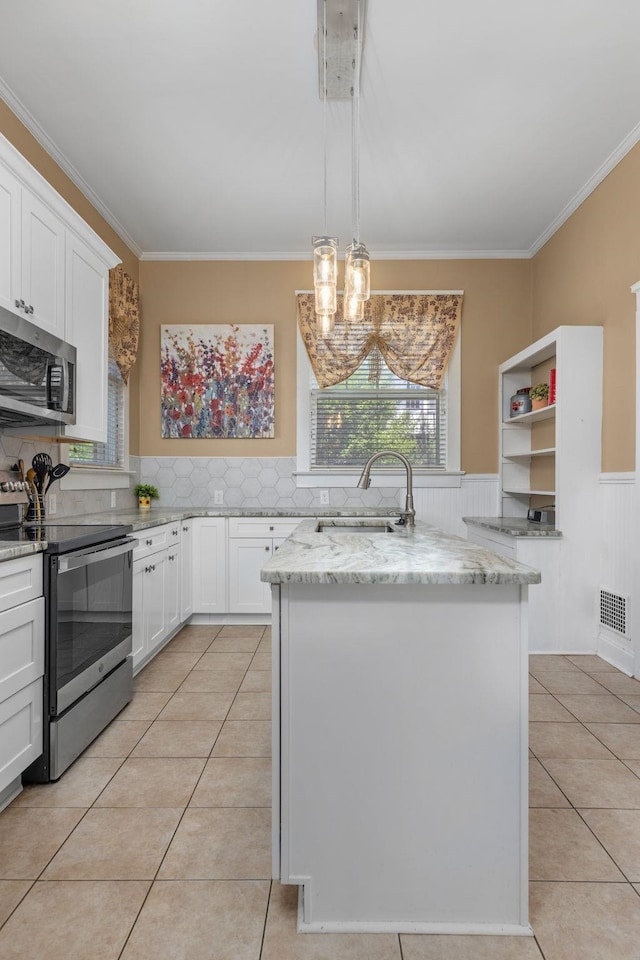 kitchen with a sink, appliances with stainless steel finishes, ornamental molding, and light tile patterned floors