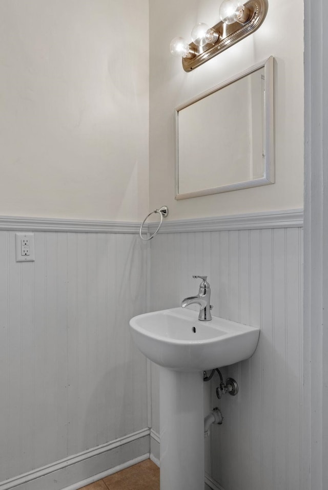 bathroom featuring a sink and a wainscoted wall
