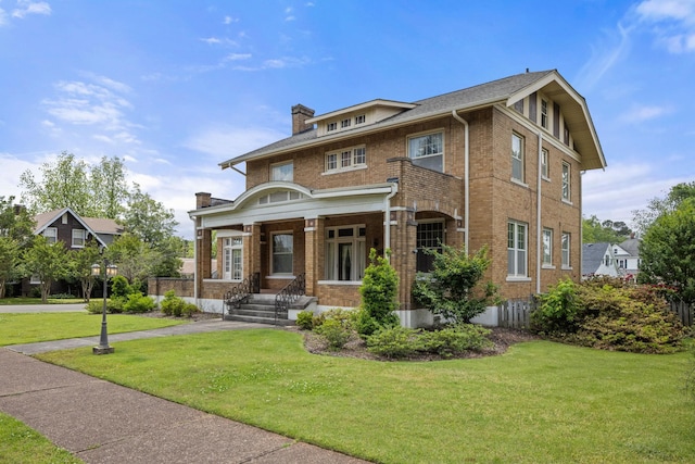 traditional style home featuring brick siding, a front lawn, covered porch, and a chimney