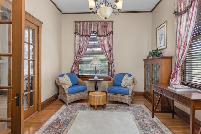 living area with plenty of natural light, wood finished floors, and a notable chandelier