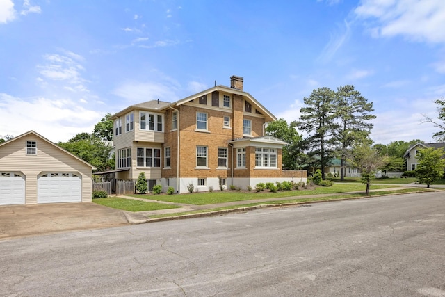 view of front of house with fence, brick siding, a garage, an outbuilding, and a chimney