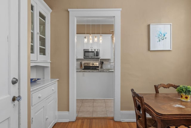 dining space featuring baseboards and light wood-style flooring