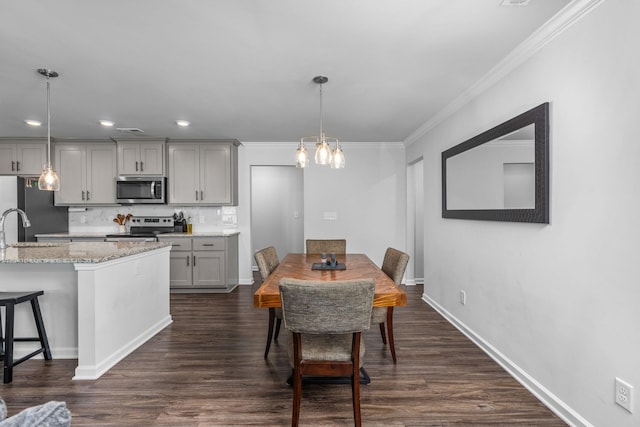 dining room featuring crown molding, sink, and dark hardwood / wood-style floors